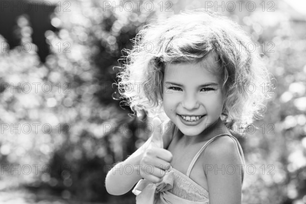 Cute little girl smiling in the park in summer day