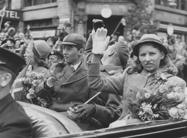 Norwegian royal family. Pictured here 1945 when returning to Norway and Oslo when world war ii was over. Crown Prince Harald, his sisters Ragnhild and Astrid and Crown Prince Olav in a car waving at the cheering crowds in a Oslo street. June 7 1945