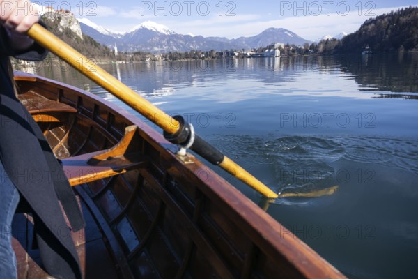 Young woman using paddle on a wooden boat, Lake Bled Slovenia rowing on wooden boats on a sunny day