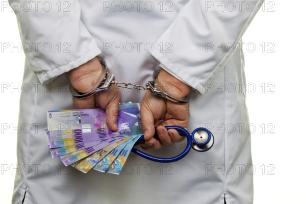 A doctor with Swiss franc banknotes and handcuffs Austria