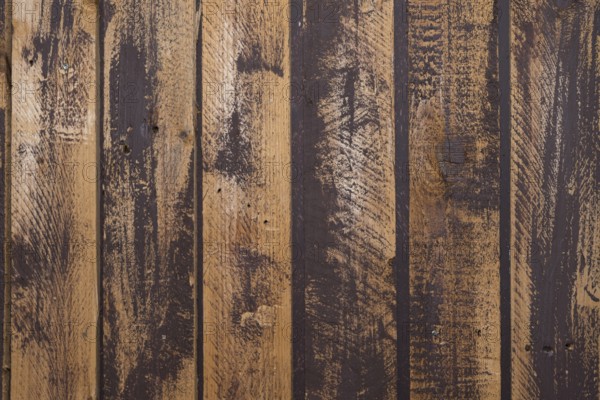 Unevenly painted dark wooden wall, uneven colour on the boards