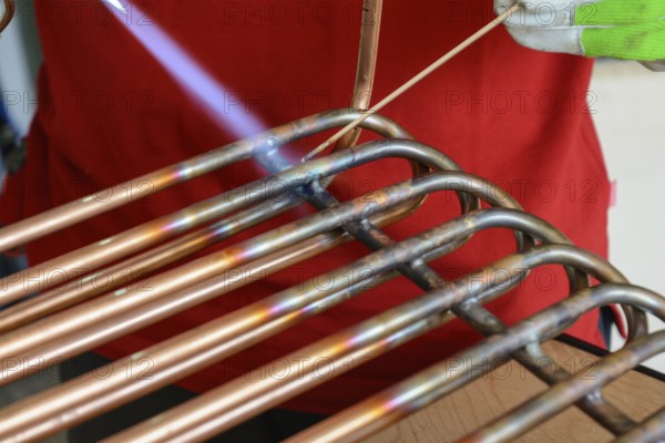 Skilled worker brazing copper - close-up