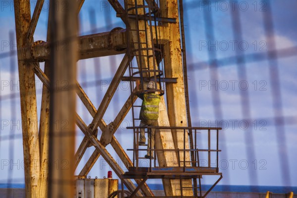 Worker climbing on a crane