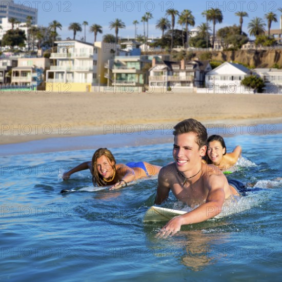 Teenager surfer group boys and girls swimming over the surfboard in santa monica california
