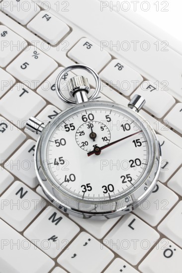 A stopwatch lies on a computer keyboard. Working time is money Austria