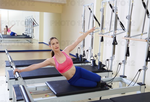 Pilates reformer woman mermaid exercise workout at gym indoor