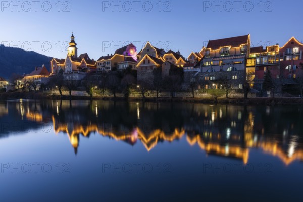 Christmas illuminated house facade of Frohnleiten reflected in the river Mur, blue hour, Frohnleiten, Styria, Austria, Europe