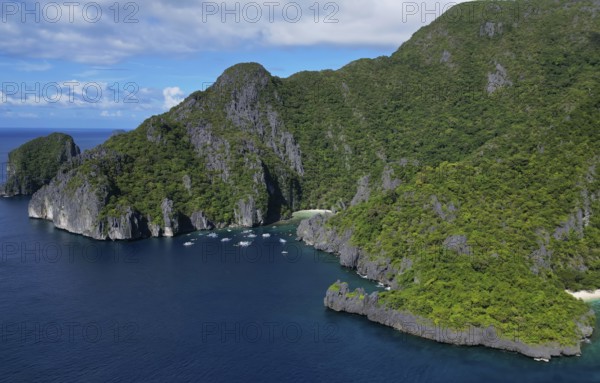 Aerial view of tropical Philippines island. White sand beach, rocks cliffs mountains with blue bay and coral reef