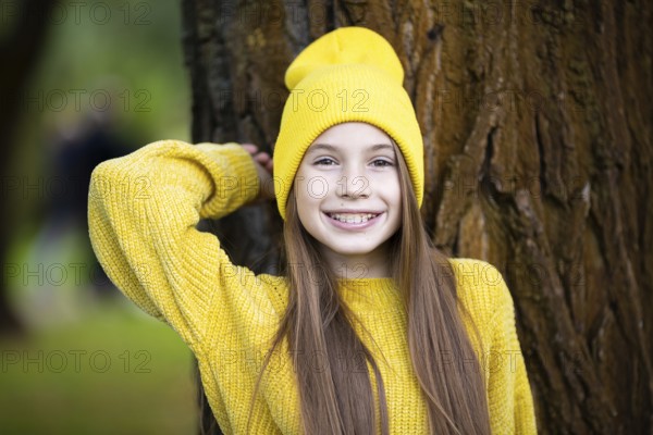 Cute and happy teenage girl with braces smiling at camera in yellow clothes in park. Concept of dentist and orthodontist. Pretty teenage girl wearing teeth appliance smiling happily outdoors
