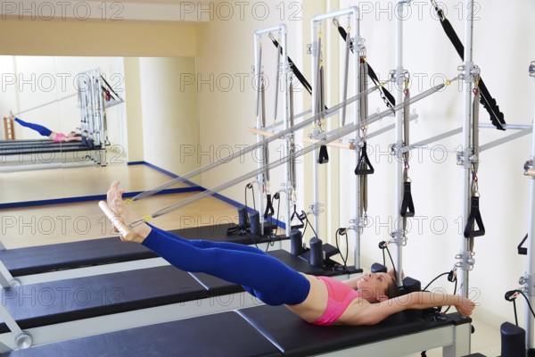 Pilates reformer woman long spine exercise workout at gym indoor