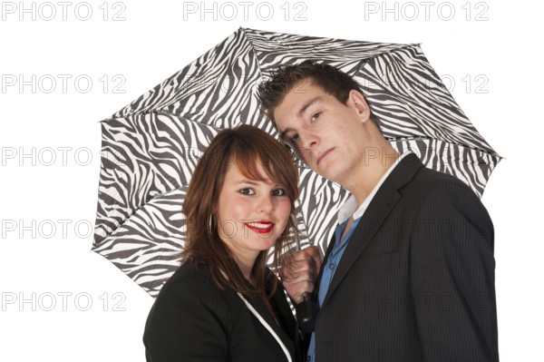 Young couple under black and white zebra umbrella