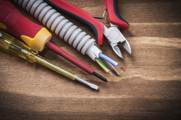 Nippers insulated screwdrivers corrugated pipe on wooden board