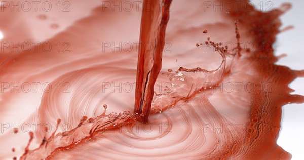 Red Wine being poured against White Background