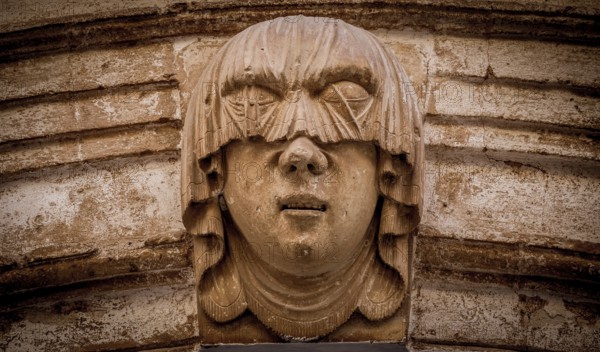 Gothic detail. Young woman portrait at the entrance of a 200 years old building in Ciutadella town, Menorca Spain