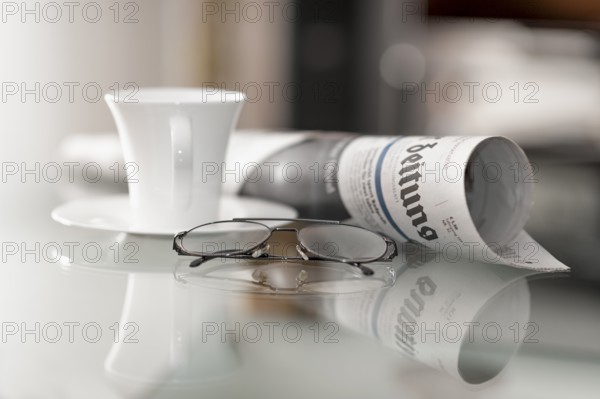Still life with daily newspaper, glasses and coffee cup