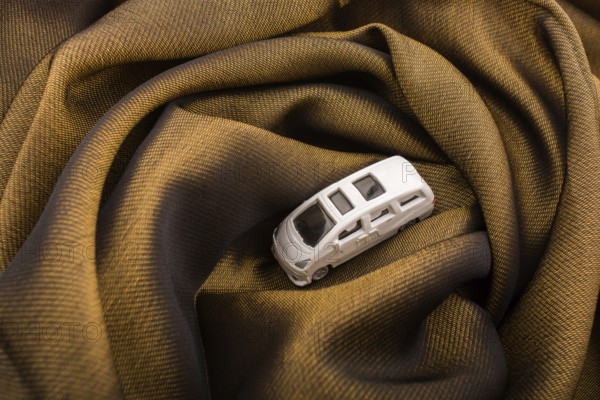 Miniature metal car on a brown fabric cloth