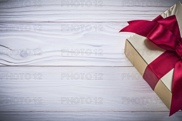 Gift container with tied bow on wooden board holiday concept