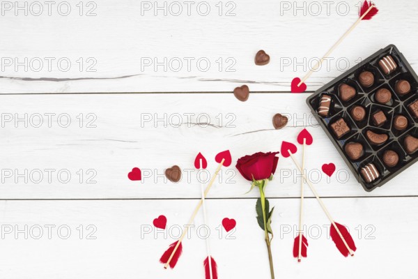 Decorative feathers wands with little hearts near flower sweets
