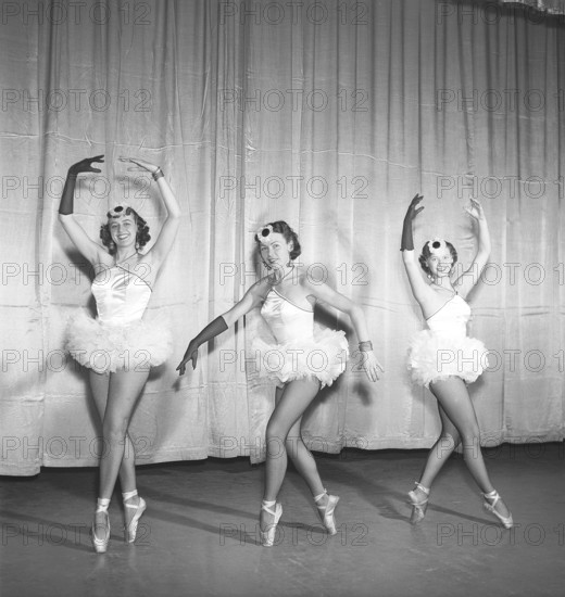 Ballerinas in the 1950s. Three young ballerinas all dressed up in their costume and shoes posing on a theatre stage in different positions. Photo Kristoffersson Ref BH41-12. Sweden 1953