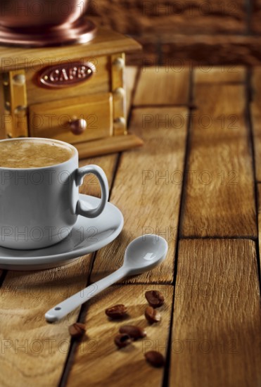Close-up coffee cup and grinder on wooden table
