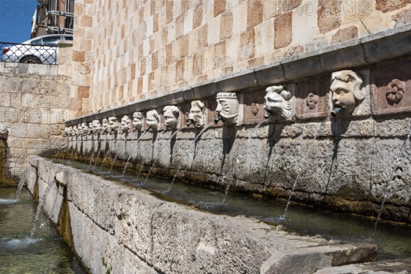 Famous mediaeval Fountain of 99 Spouts in ithe old town of L'Aquila, Abruzzi in Italy