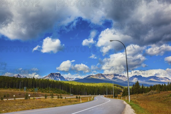 Perfect Canadian highway amidst evergreen forests and snow-capped mountains