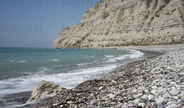 Empty pebble tropical beach under white cliffs against blue sky. Pissouri coastline Limassol Cyprus Europe