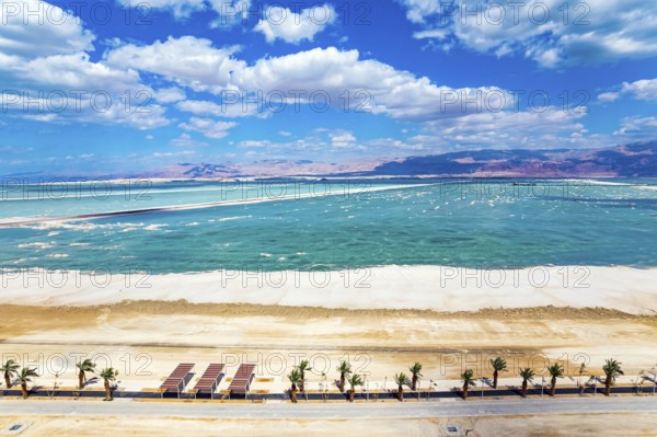 The Dead Sea is an endorheic salt lake. Israel. Magnificent resort for treatment and relaxation. Drone filming. The picturesque embankment is lined with palm trees