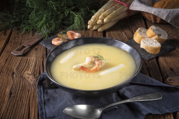 Delicious asparagus cream soup with prawns and fresh dill