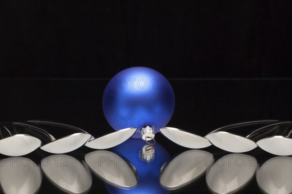 Blue Christmas decoration and six spoons on a black glass desk