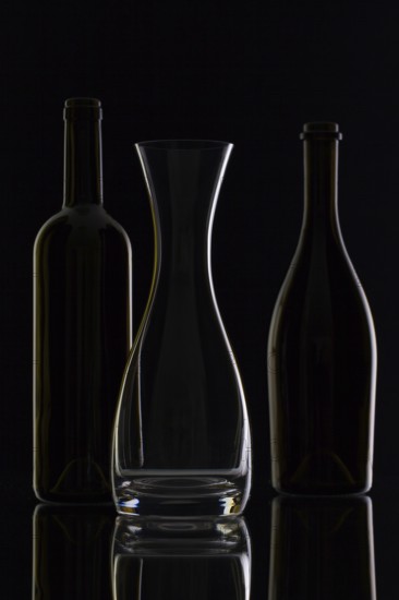 Empty glass and bottles on the black background