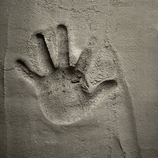 Hand print on cement mortar wall with shadow relief