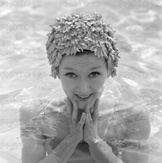 In the 1960s. A young woman pictured in the swimming pool wearing a typical 1960s bathing cap in a plastic material. Sweden 1960