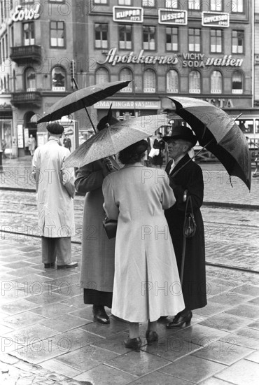 Umbrellas in the 1950s. A group of elderly women are standing together under their umbrellas. It's a rainy day in Stockholm Sweden 1953. ref 2A-1