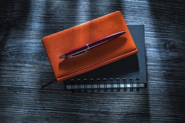 Notebooks pen on vintage wooden board