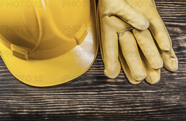 Safety gloves building helmet on wooden board construction concept