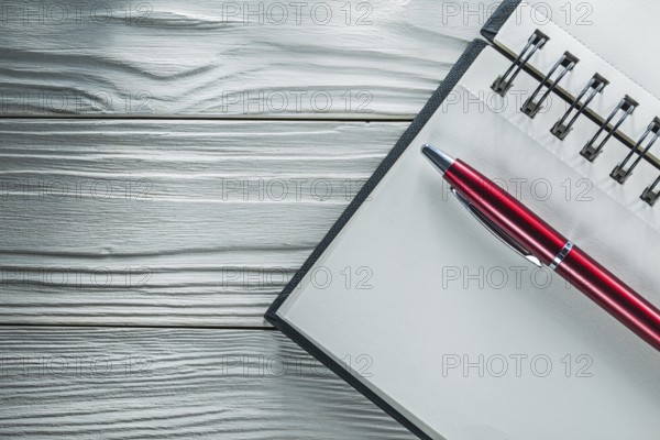 Opened notepad pen on white wooden board