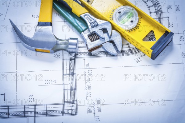Claw hammer adjustable spanners construction level on blueprint maintenance concept