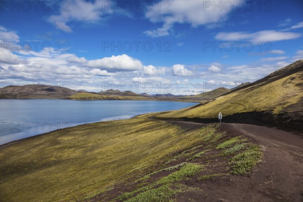 Summer travel to Iceland. Rhyolitic mountains surround the volcanic lake with cold water
