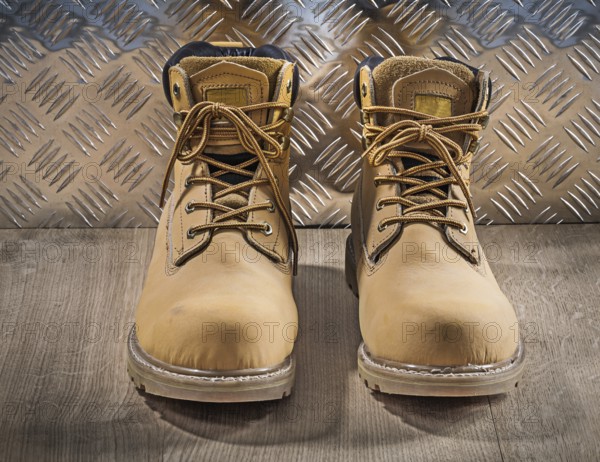 Safety waterproof lace shoes wooden board corrugated metal plate construction concept