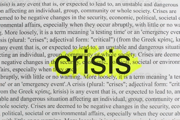 Typed text Crisis on white paper.Yellow marked