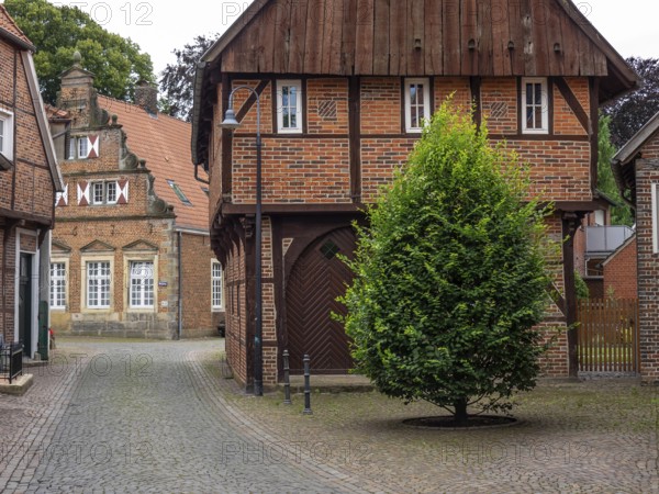 Narrow cobbled alley with charming brick houses, Legden, münsterland, germany