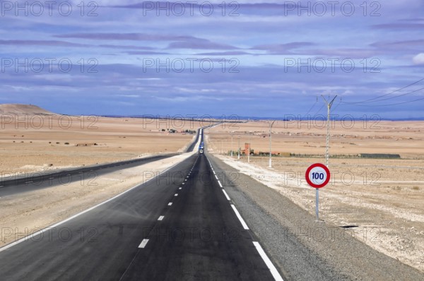 Drive to Essaouira, Morocco, Africa, endless road in a desert landscape with 100 km/h road signs and power lines along the road, Africa