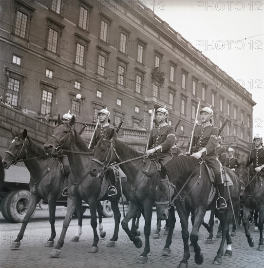 1940s soldiers on horses. In the street with the royal castle in Stockholm in the background, soldiers are riding by for the changing of the guards ceremony. Ref Kristoffersson AD32-8. 1947