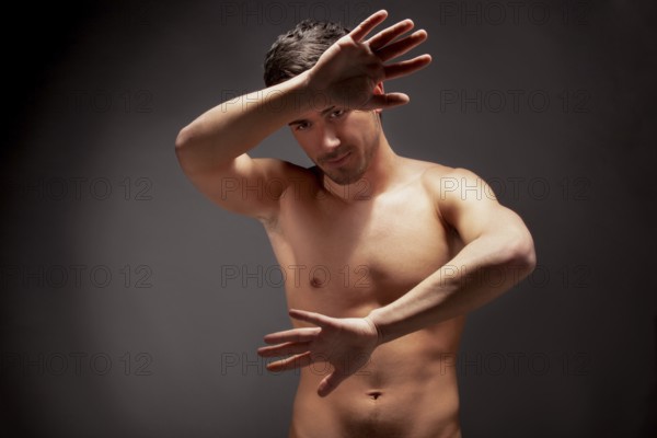 Young muscular man with a bare chested on black