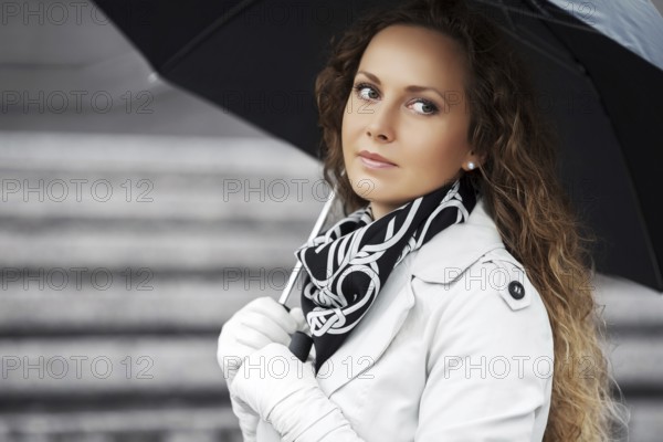 Beautiful woman with umbrella in the rain