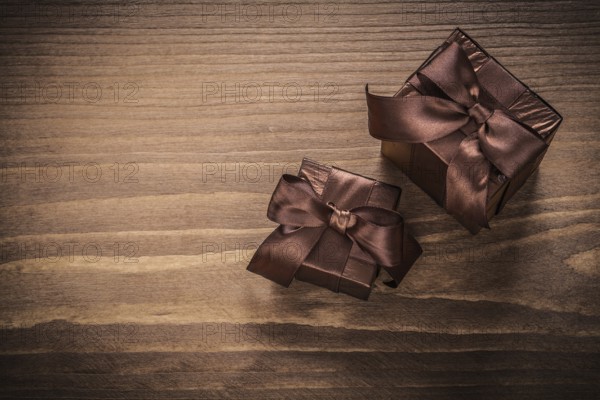 Packed glittery gift containers with ribbons on vintage wooden board