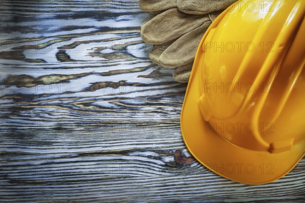 Safety gloves building helmet on vintage wooden board