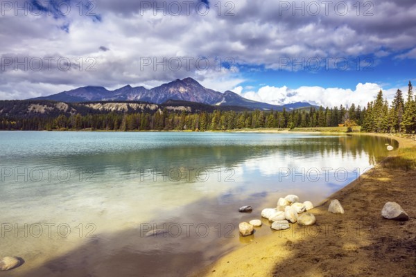 Pretty round lake in the coniferous forest. Canadian Rocky Mountains, Jasper National Park, lake Annette