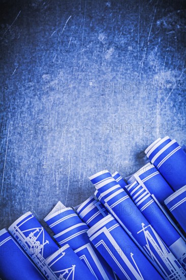 Blue blueprints on scratched metallic background construction concept
